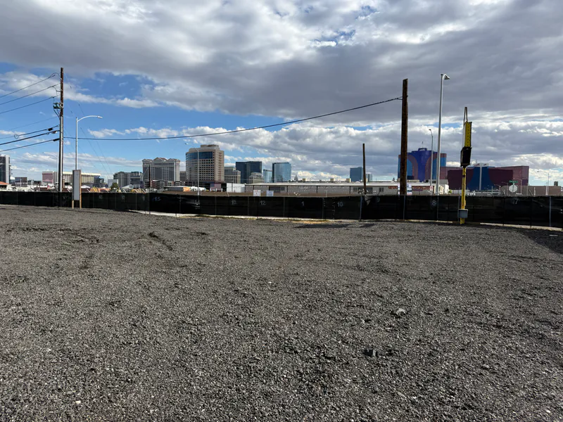 Graded gravel Personal Storage Lot with the Las Vegas Strip skyline behind privacy-screened perimeter fencing